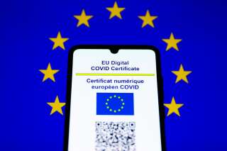 EU Digital COVID Certificate is displayed on a mobile phone screen photographed with EU flag background for illustration photo during the coronavirus pandemic. Krakow, Poland on July 17, 2021.  (Photo by Beata Zawrzel/NurPhoto via Getty Images)