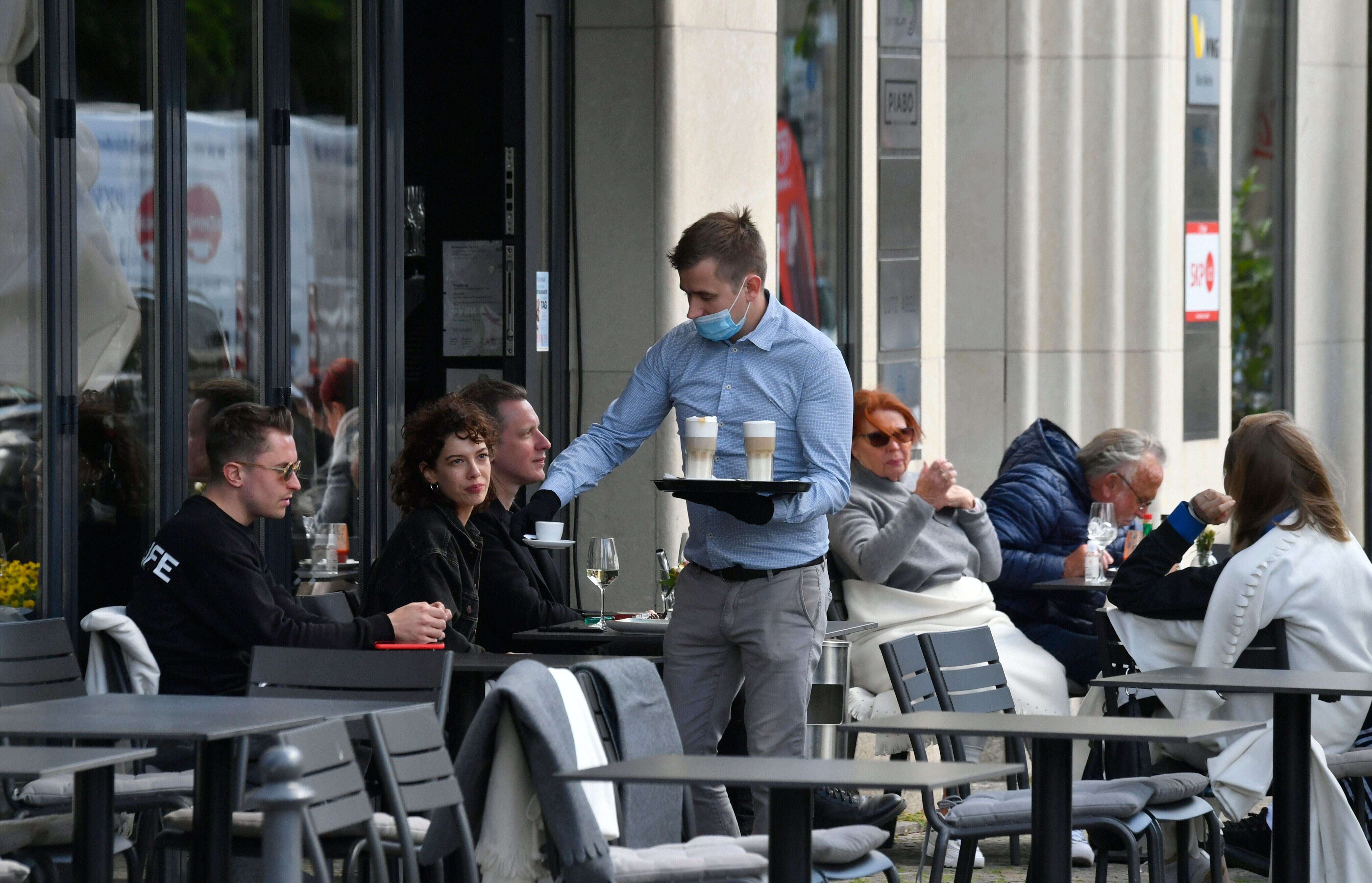 Un serveur apportant des commandes en terrasse dans un café de Berlin, le 15 mai 2020.