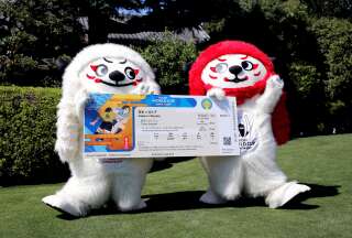 Les mascottes officielles de la Coupe du monde de rugby au Japon tiennent une réplique des tickets d'entrée pour les matchs, à Tokyo, le 17 juin 2019.