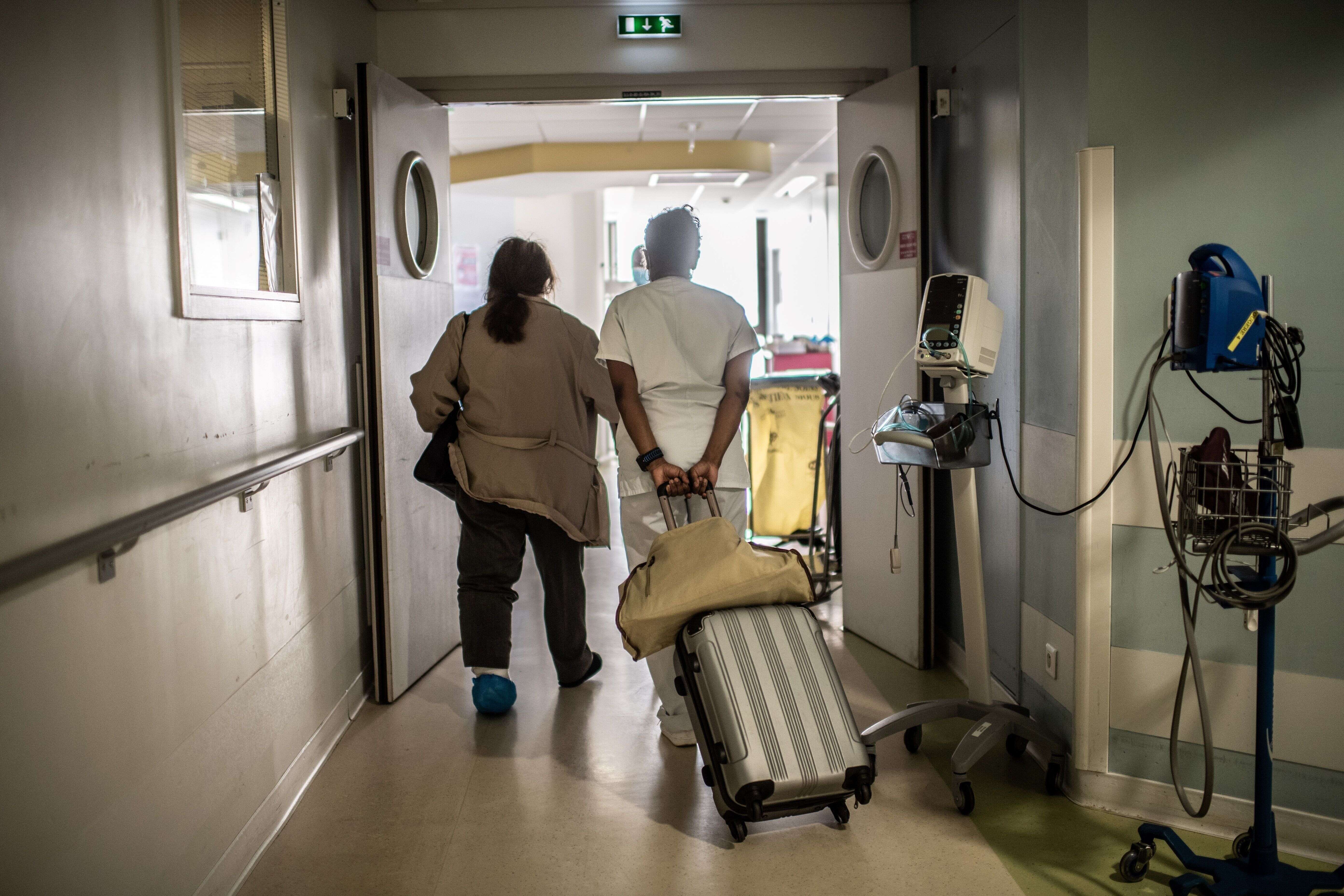 Une infirmière aide une patiente avec sa valise, à l'hôpital Saint-Louis à Paris, le 28 mai 2020.