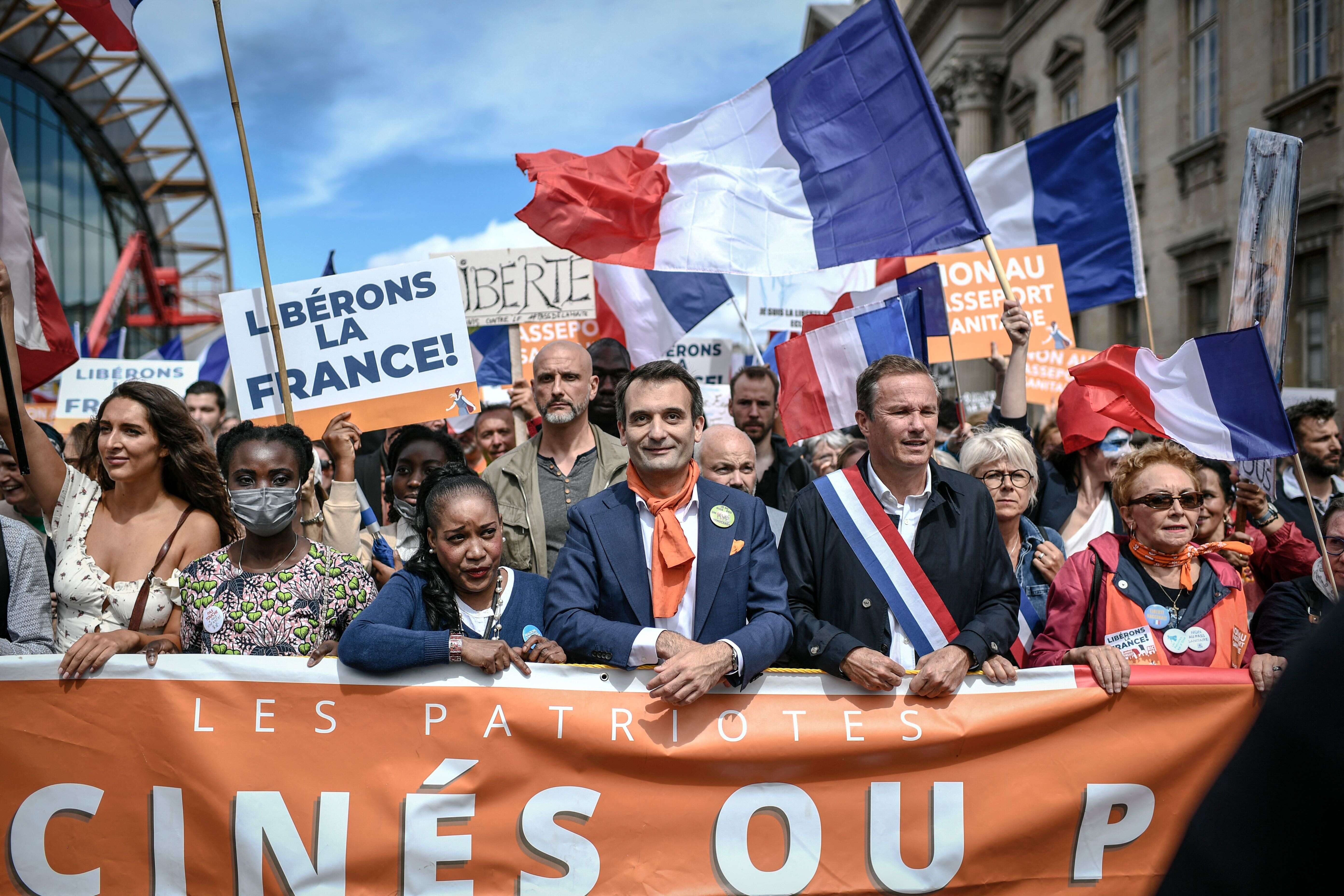 Florian Philippot, au centre et Nicolas Dupont-Aignan, à sa droite, lors d'une manifestation contre le pass sanitaire le 7 août 2021