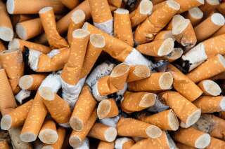 This photograph shows a multitude of cigarette butts in an ashtray.  The cigarettes are unbranded.