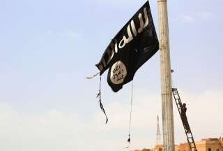 Un coup de filet visant à démanteler un réseau de cyberfinancement du terrorisme au profit d'Al-Qaïda et du groupe État islamique a eu lieu ce mardi (Image d'illustration: un membre des Forces démocratique syriennes enlève un drapeau de Daech à Tabqa, près de Raqa en Syrie, en avril 2017).