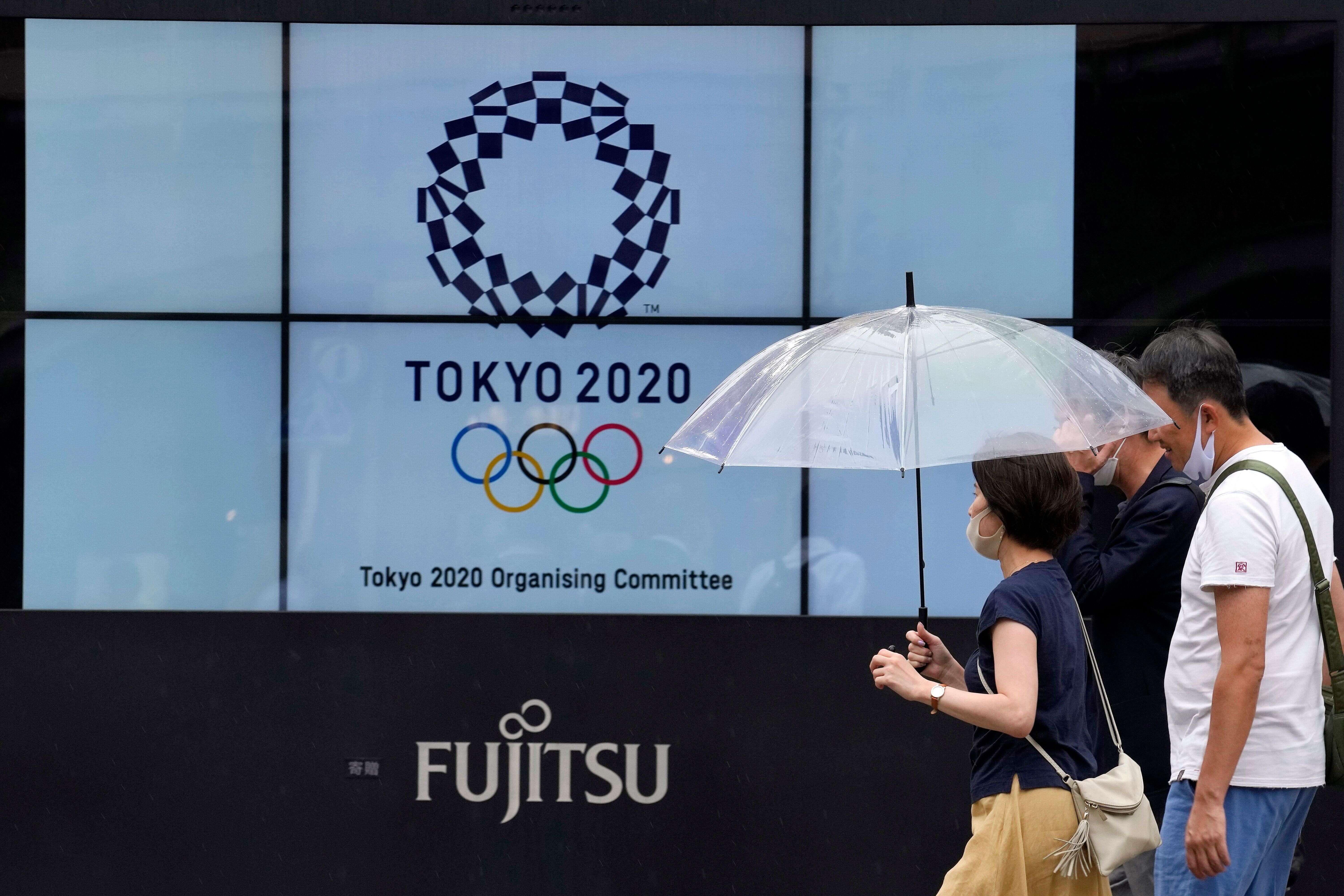 Des passants à Tokyo, où se tiennent les Jeux olympiques, le 9 juillet 2021.