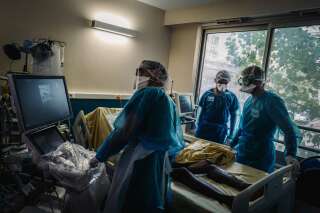 Du personnel médical transporte un patient atteint du Covid-19 à l'hôpital Lariboisière le 14 octobre 2020 (Photo by LUCAS BARIOULET/AFP via Getty Images)
