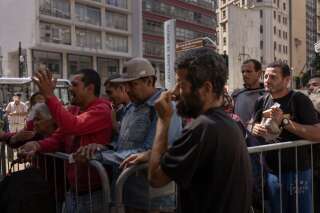 Des sans-abri font la queue pour obtenir des vivres devant un centre de dépistage, à São Paulo.