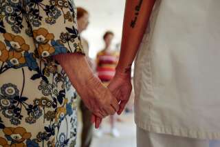 Une art-thérapeute tient la main d'une femme âgée, dans un Ehpad de Nice, le 4 août 2020.