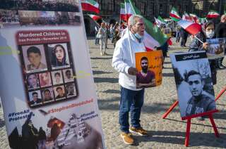 Des manifestants brandissent des portraits du lutteur iranien Navid Afkari lors d'une manifestation à Amsterdam, aux Pays-Bas, le 13 septembre 2020, pour protester contre son exécution et contre le gouvernement iranien. L'Iran a déclaré avoir exécuté Navid Afkari, 27 ans, le 12 septembre 2020 dans une prison de Chiraz, pour le meurtre d'un policier lors des manifestations antigouvernementales d'août 2018. Des rapports publiés à l'étranger indiquent que Navid Afkari aurait été condamné sur la base d'aveux extorqués sous la torture. (Photo EVERT ELZINGA/ANP/AFP via Getty Images)