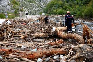 Des pompiers travaillant pour enlever les arbres tombés sur la route endommagée menant à Breil-sur-Roya, dans les Alpes-Maritimes, le 6 octobre 2020.