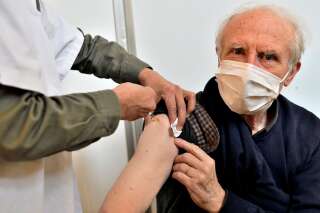 Une infirmière injecte à une personne agée portant un masque le vaccin Pfizer-BioNTech contre la Covid 19, le 6 mars 2021 à Paris.