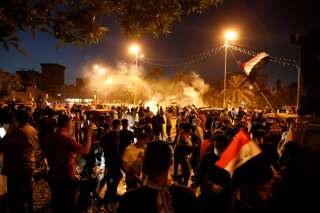Des manifestants face aux forces de sécurité utilisant des gaz lacrymogènes à Bagdad, en Irak, ce 26 octobre.