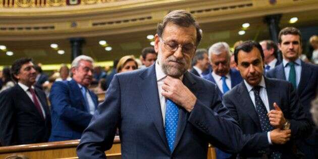Spain's acting Prime Minister and Popular Party leader Mariano Rajoy adjusts his tie as he leaves at the end of the first of the two-day investiture debate at the Spanish parliament in Madrid, Tuesday, Aug. 30, 2016. Rajoy started a two-day parliamentary debate later Tuesday ahead of a vote on his bid to form a minority government and end an eight-month political impasse, but the signs are he won't be successful. (AP Photo/Francisco Seco)
