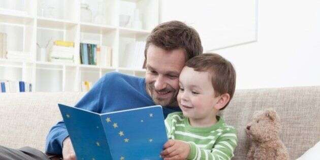 Germany, Bavaria, Munich, Father and boy (2-3 Years) reading a book