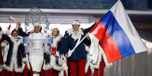 FILE - In this Feb. 7, 2014 file photo Alexander Zubkov of Russia carries the national flag as he leads the team during the opening ceremony of the 2014 Winter Olympics in Sochi, Russia.  On Monday, July 18, 2016 a report on Russian doping by investigator Richard McLaren is to be released in Toronto.   (AP Photo/Mark Humphrey, file)