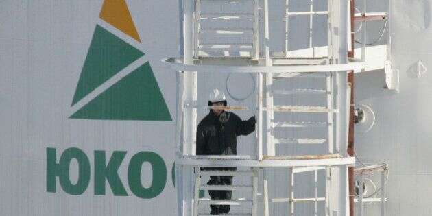 A worker climbs up the stairs of an oil container at the pumping station near the Priobskoye oil field, some 150 km from the Siberian town of Khanty-Mansiysk, March 22, 2005. Priobskoye was a jewel field in the crown of oil firm Yugansk, formerly a key oil producing unit of oil major YUKOS. Yugansk was re-nationalised last December to recover YUKOS's back taxes and is now controlled by state oil firm Rosneft. Picture taken March 22, 2005. REUTERS/Sergei Karpukhin  CVI/SM