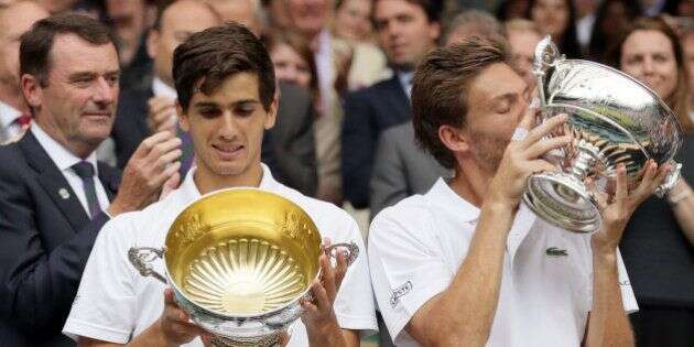 Nicolas Mahut of France, right, and playing partner Pierre-Hughes Herbert of France hold their trophies after winning the men's doubles final against Julien Benneteau and Edouard Roger-Vasselin of France on day thirteen of the Wimbledon Tennis Championships in London, Saturday, July 9, 2016. (AP Photo/Tim Ireland)