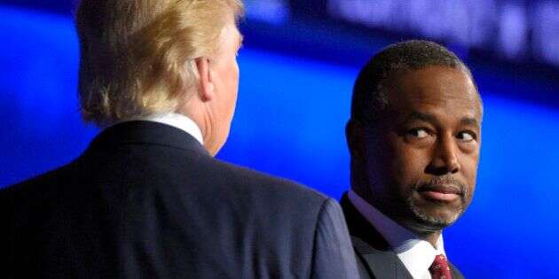Ben Carson watches as Donald Trump takes the stage during the CNBC Republican presidential debate at the University of Colorado, Wednesday, Oct. 28, 2015, in Boulder, Colo. (AP Photo/Mark J. Terrill)