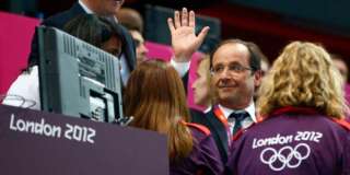 France's President Francois Hollande waves as he is accompanied to his seat by British Prime Minister David Cameron (L) during the women's handball Preliminaries Group B match between France and Spain at the Copper Box venue during the London 2012 Olympic Games July 30, 2012. REUTERS/Marko Djurica (BRITAIN  - Tags: POLITICS SPORT HANDBALL SPORT OLYMPICS)