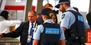 La police fédérale australienne contrôle des passagers à l'aéroport de Sydney, le 30 juillet.