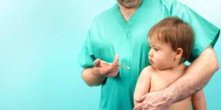 Doctor giving baby boy injection
