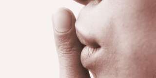 close-up of a persons finger on the lips (sepia)