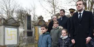 Emmanuel Macron tient la main d'enfants au moment où il visite le cimetière juif profané de Quatzenheim, en Alsace, le 19 février 2019.