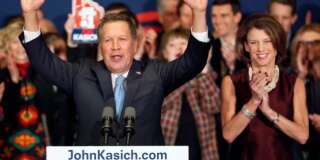 With his wife Karen at his side Republican presidential candidate Gov. John Kasich, R-Ohio, waves to supporters Tuesday, Feb. 9, 2016, in Concord, N.H., at his primary night rally. (AP Photo/Jim Cole)