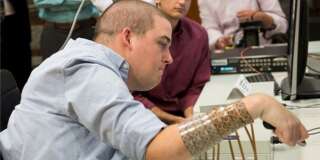Ian Burkhart, 24, is shown using neural bypass technology in this undated handout picture released by Ohio State University Wexner Medical Center in Columbus, Ohio.Burkhart, who became paralysed in an accident, can now move his hands thanks to a computer chip in his brain that lets his mind guide his hands and fingers, bypassing his damaged spinal cord.   REUTERS/The Ohio State University Wexner Medical Center/Battelle/Handout via Reuters      ATTENTION EDITORS - THIS PICTURE WAS PROVIDED BY A THIRD PARTY. REUTERS IS UNABLE TO INDEPENDENTLY VERIFY THE AUTHENTICITY, CONTENT, LOCATION OR DATE OF THIS IMAGE. EDITORIAL USE ONLY. NOT FOR SALE FOR MARKETING OR ADVERTISING CAMPAIGNS. NO RESALES. NO ARCHIVE. THIS PICTURE IS DISTRIBUTED EXACTLY AS RECEIVED BY REUTERS, AS A SERVICE TO CLIENTS