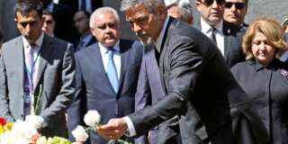 US actor George Clooney, foreground, puts a flower, as he attends a ceremony at a memorial to Armenians killed by the Ottoman Turks, in Yerevan, Armenia on Sunday, April 24, 2016. The killing of more than 200 Armenian intellectuals on April 24, 1915 is regarded as the start of the massacre that is widely viewed by historians as genocide. But modern Turkey, the successor to the Ottoman Empire, vehemently rejects the charge. Clooney has been a prominent voice in favor of countries recognizing the killings as genocide, which the United States has not done. (Vahan Stepanyan/ PAN Photo via AP)