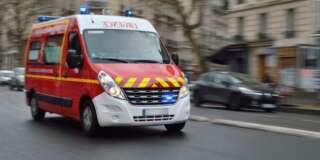 Red emergency vehicle speeding on Paris street