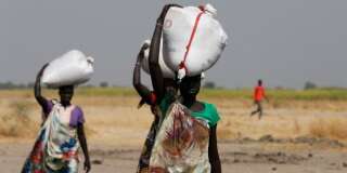 Des portent des sacs de nourriture à Nimini, au nord du Soudan du Sud ravagé par la guerre et la famine, le 8 février 2017