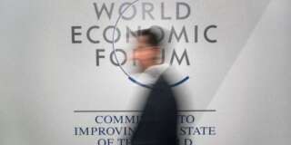 A participant walks past a logo during the World Economic Forum (WEF) annual meeting in Davos, on January 20, 2016.  A string of jihadist attacks and rising risks to the global economy overshadow the opening of the annual gathering of the world's rich and powerful in a snow-blanketed Swiss ski resort. Even as heads of state, billionaires and Hollywood megastar Leonardo DiCaprio were arriving, the International Monetary Fund (IMF) sounded the alarm on January 19, 2016 about perils in the major emerging market economies and lowered its outlook for global economic growth this year. / AFP / FABRICE COFFRINI        (Photo credit should read FABRICE COFFRINI/AFP/Getty Images)