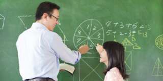 Teacher teach student how to solve the math questions in the classroom