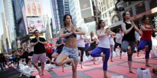 NEW YORK - JUNE 21: Over 8,000 people practice yoga as a salute to the sun at the 12th Annual Solstice in Times Square on June 21, 2014 in New York City.  The day-long, free yoga event was sponsored by Athleta and the Times Square Alliance.   (Photo by Yana Paskova/Getty Images)