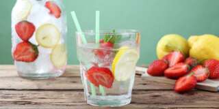 ice long drink strawberry and lemon in glass  green background