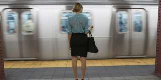 Caucasian woman standing near passing subway in train station