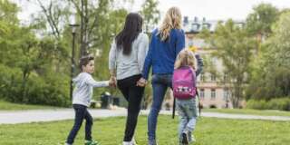 Rear view of female homosexual family walking in park