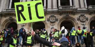 Un manifestant gilet jaune réclamant le RIC samedi 15 décembre à Paris.