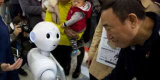 Le robot Pepper et des visiteurs de la World Robot Conference de Pekin en Chine, le 21 octobre 2016. (AP Photo/Ng Han Guan)
