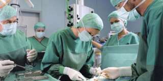 Group of surgeons working in operating theatre