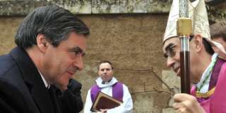 Francois Fillon salue l'évêque Alain Castet lors d'une messe en hommage aux victimes de la tempête Xynthia, le 4 mars 2010.  REUTERS/Franck Perry/Pool