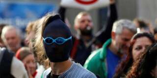 A masked demonstrator protests outside a congress centre where negotiators are expected to discuss the 14th Round of the Transatlantic Trade and Investment Partnership (TTIP) in Brussels, Belgium, July 12, 2016. REUTERS/Francois Lenoir
