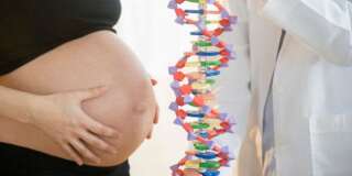Pregnant woman and doctor examining DNA model
