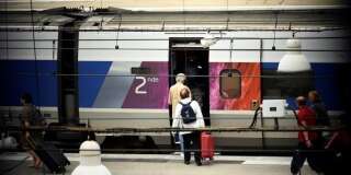 Des voyageurs montent dans un train en gare Montparnasse à Paris, le 1er août.
