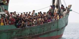 Rohingya and Bangleshi migrants wait on board a fishing boat before being transported to shore, off the coast of Julok, in Aceh province, May 20, 2015 in this photo taken by Antara Foto.  Hundreds of Rohingya and Bangladeshi migrants landed in Indonesia's northwestern Aceh province early on Wednesday, an Indonesian search and rescue official said. REUTERS/Syifa/Antara Foto  ATTENTION EDITORS - THIS IMAGE HAS BEEN SUPPLIED BY A THIRD PARTY. IT IS DISTRIBUTED, EXACTLY AS RECEIVED BY REUTERS, AS A SERVICE TO CLIENTS. MANDATORY CREDIT. INDONESIA OUT. NO COMMERCIAL OR EDITORIAL SALES IN INDONESIA. FOR EDITORIAL USE ONLY. NOT FOR SALE FOR MARKETING OR ADVERTISING CAMPAIGNS	       TPX IMAGES OF THE DAY