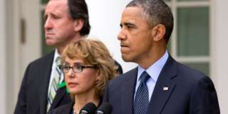 Neil Heslin, father of Newtown victim Jesse Lewis, left, and former Rep. Gabby Giffords, D-Ariz.,  stand with President Barack Obama as he pauses while surrounded by Newtown families and speaking about measures to reduce gun violence, in the Rose Garden of the White House, in Washington, Wednesday, April 17, 2013. (AP Photo/Jacquelyn Martin)