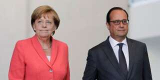 German Chancellor Angela Merkel, right, and French President Francois Hollande arrive for a press statement about the European migrant crisis prior to a meeting at the chancellery  in Berlin, Monday, Aug. 24, 2015. (AP Photo/Markus Schreiber).