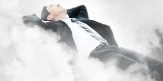 Businessman laying on the clouds