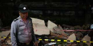 Un policier devant les ruines d'un immeuble à Bali, après le nouveau séisme à Lombok, le 5 août.