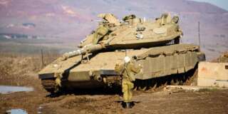 A soldier from the IDF's Artillery Corps prepares a Merkava tank on Israel's border with Syria in the Golan Heights. The army position is located on the border with the Syrian town of al-Quneitra where Bashar al-Assad, ISIS, and Syrian rebels have been in a constant battle over the territory. Israel has experienced sporadic fire and shelling from the conflict in Syria. Mt. Hermon can be seen in the background of the image.